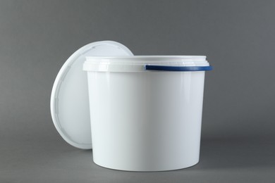 One plastic bucket and lid on grey background