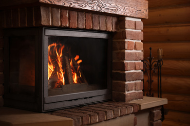 Photo of Fireplace with burning wood indoors. Winter vacation