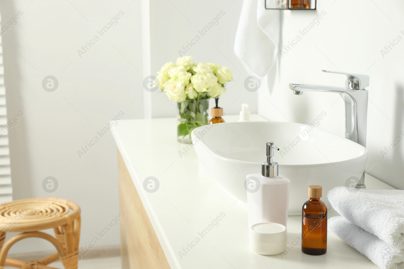 Photo of Bath accessories, sink and roses in bathroom