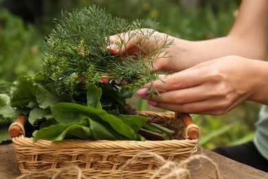 Photo of Woman with fresh green herbs outdoors, closeup