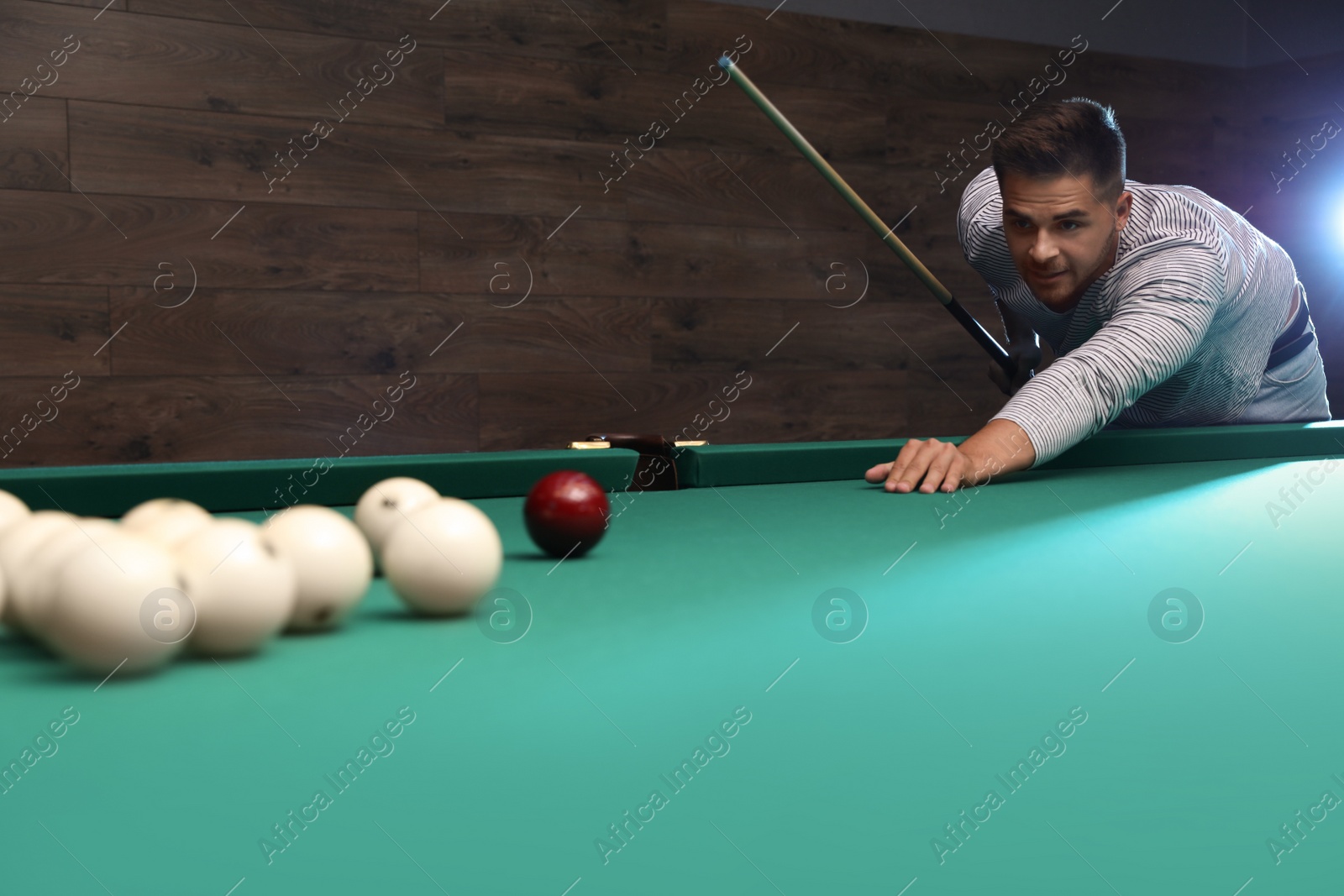 Photo of Handsome young man playing Russian billiard indoors. Space for text