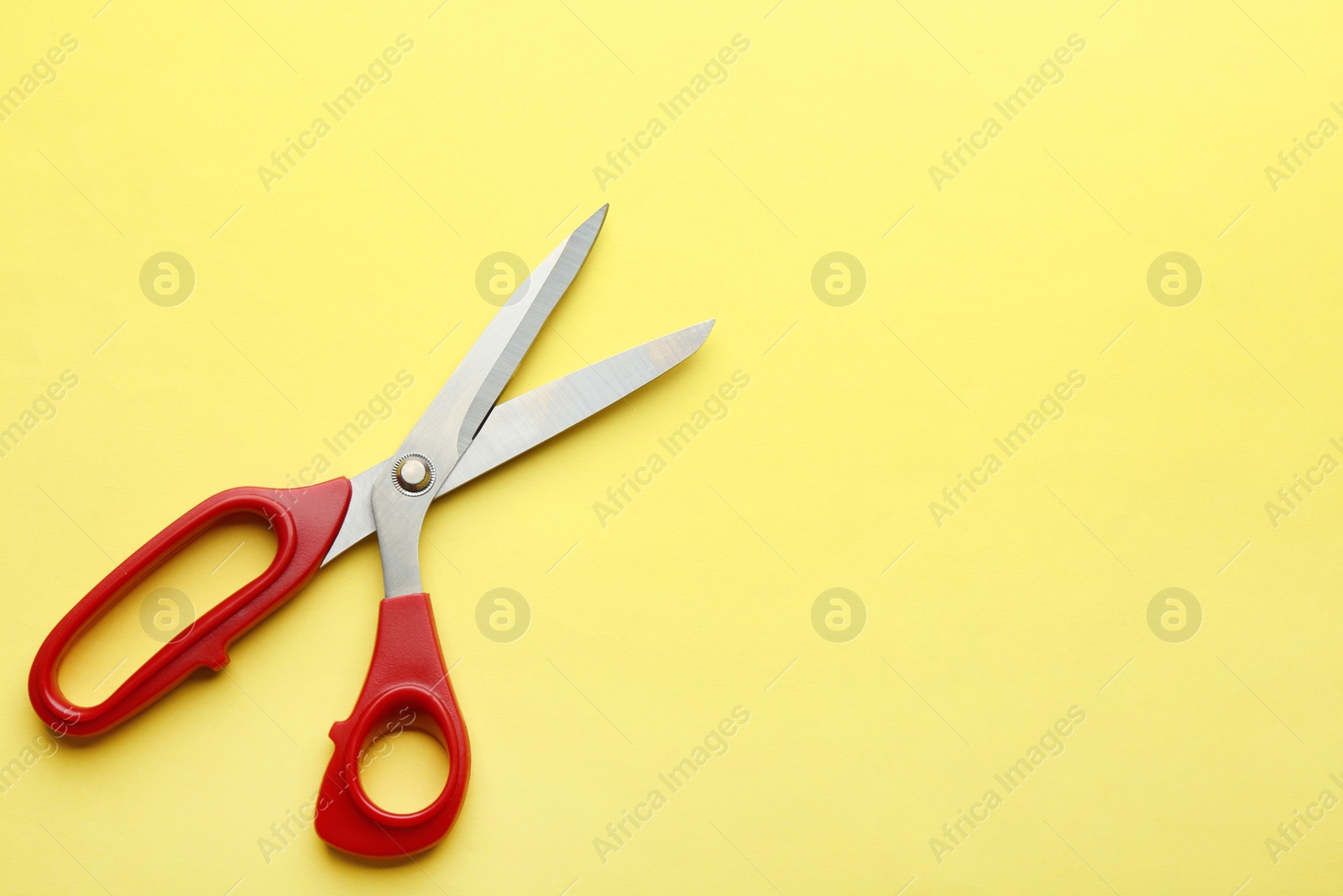 Photo of Pair of sharp scissors on color background, top view. Space for text