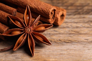 Photo of Aromatic anise star and cinnamon sticks on wooden table, closeup