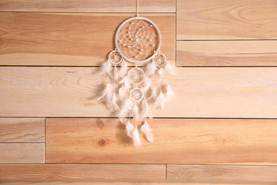Photo of Beautiful dream catcher hanging on wooden wall