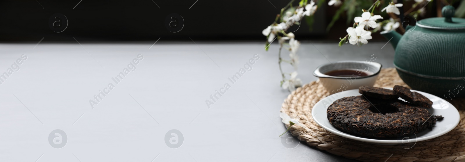 Image of Aromatic pu-erh tea on grey table. Banner design with space for text