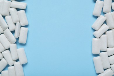 Tasty white chewing gums on light blue background, flat lay. Space for text