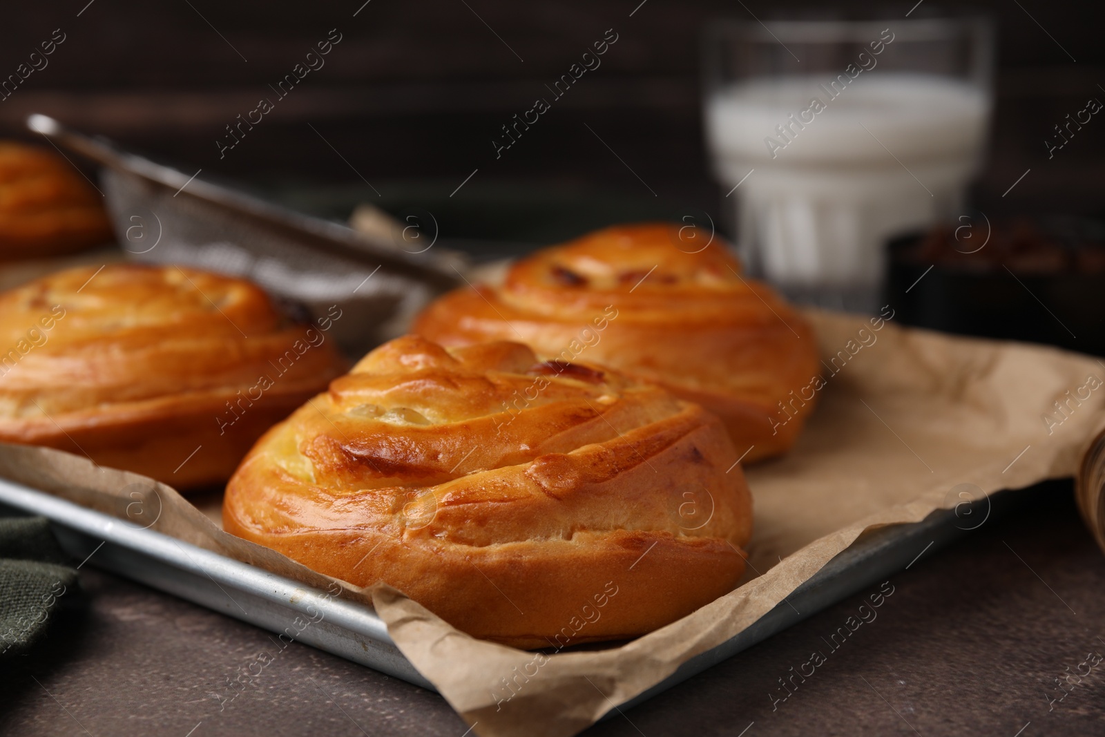 Photo of Delicious rolls on brown textured table, closeup. Sweet buns