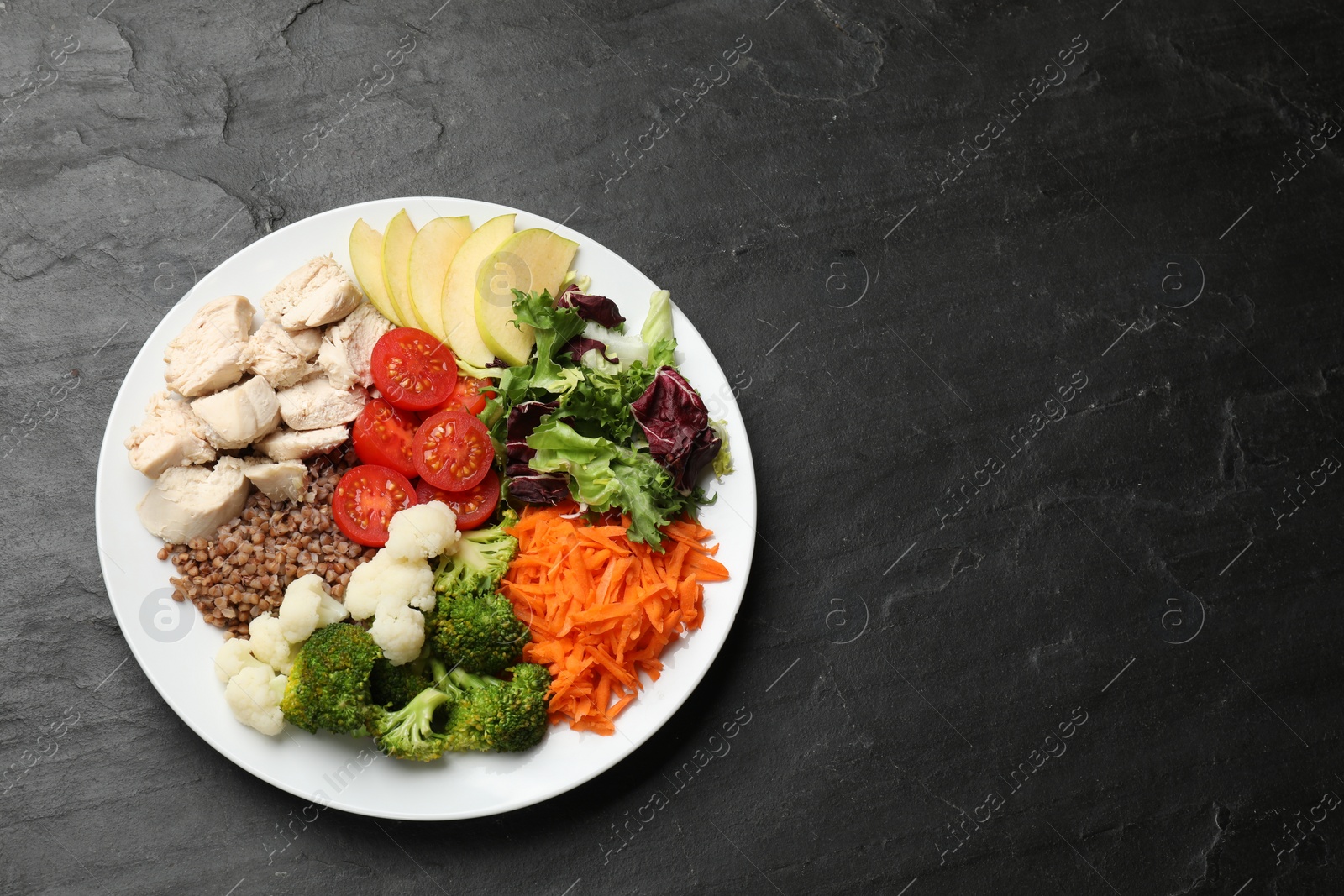 Photo of Balanced diet and healthy foods. Plate with different delicious products on black table, top view. Space for text