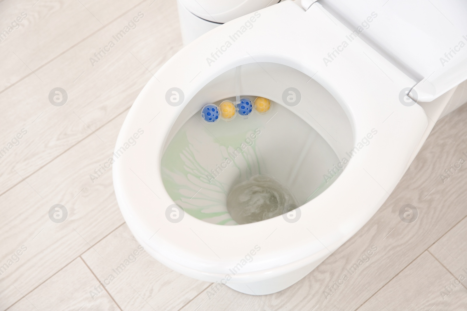 Photo of Ceramic toilet bowl with detergent in modern bathroom