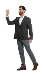 Photo of Handsome man waving to say hello while walking on white background
