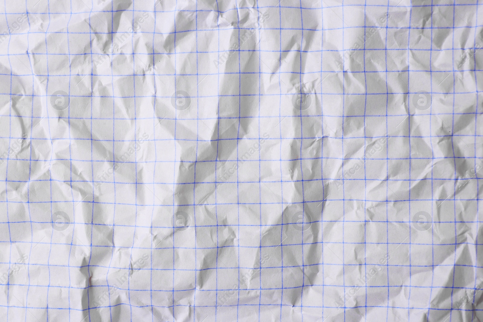 Photo of Sheet of crumpled checkered paper as background, top view