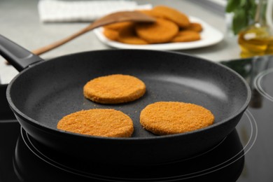 Photo of Cooking breaded cutlets in frying pan on stove