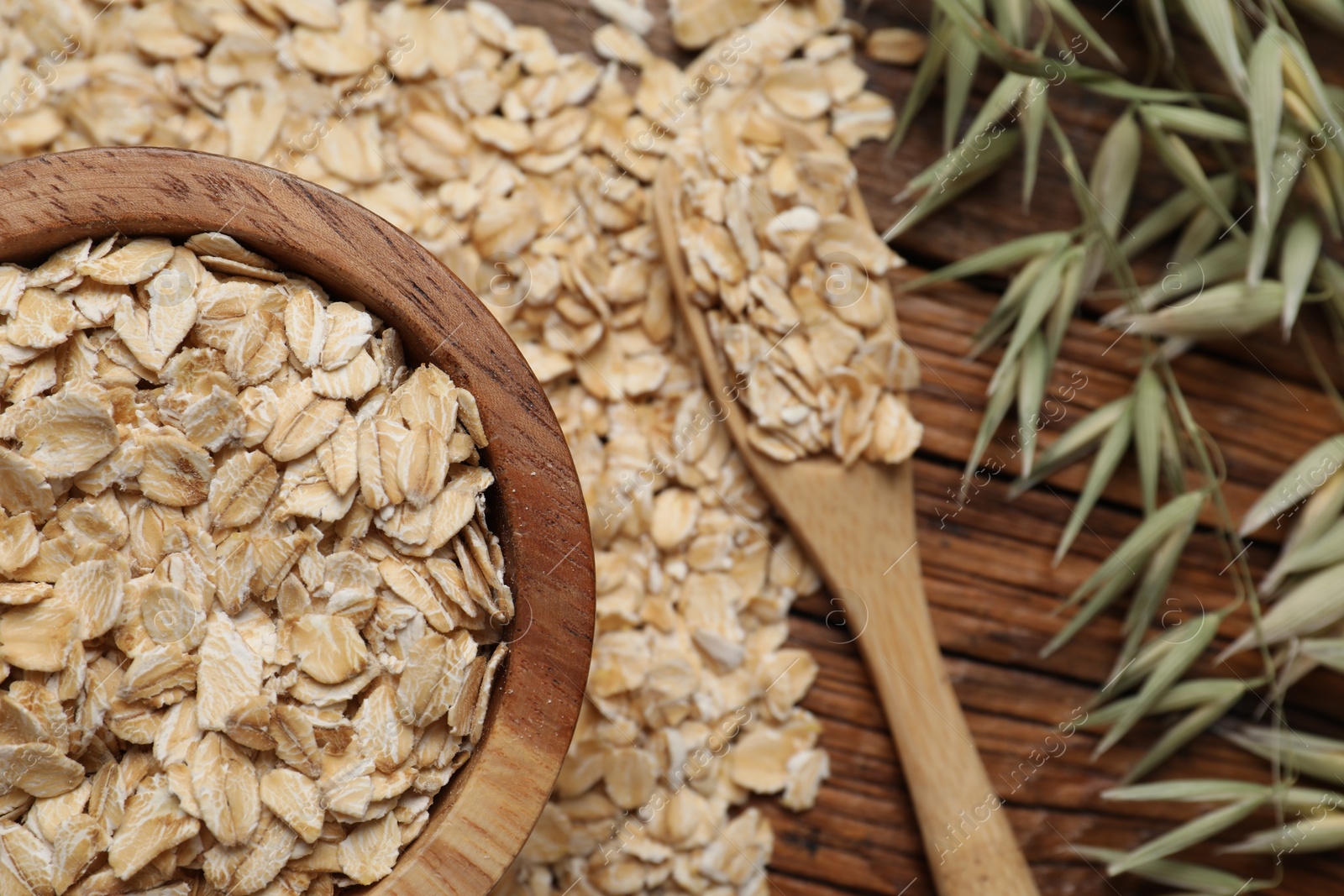 Photo of Oatmeal and florets on wooden table, flat lay