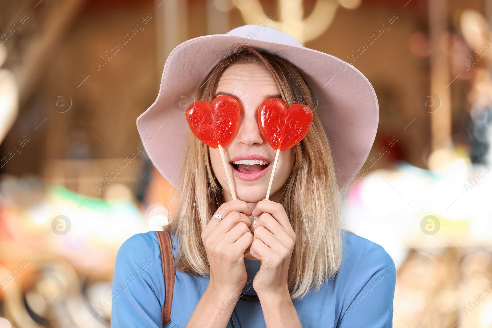 Photo of Beautiful woman with candies having fun at amusement park