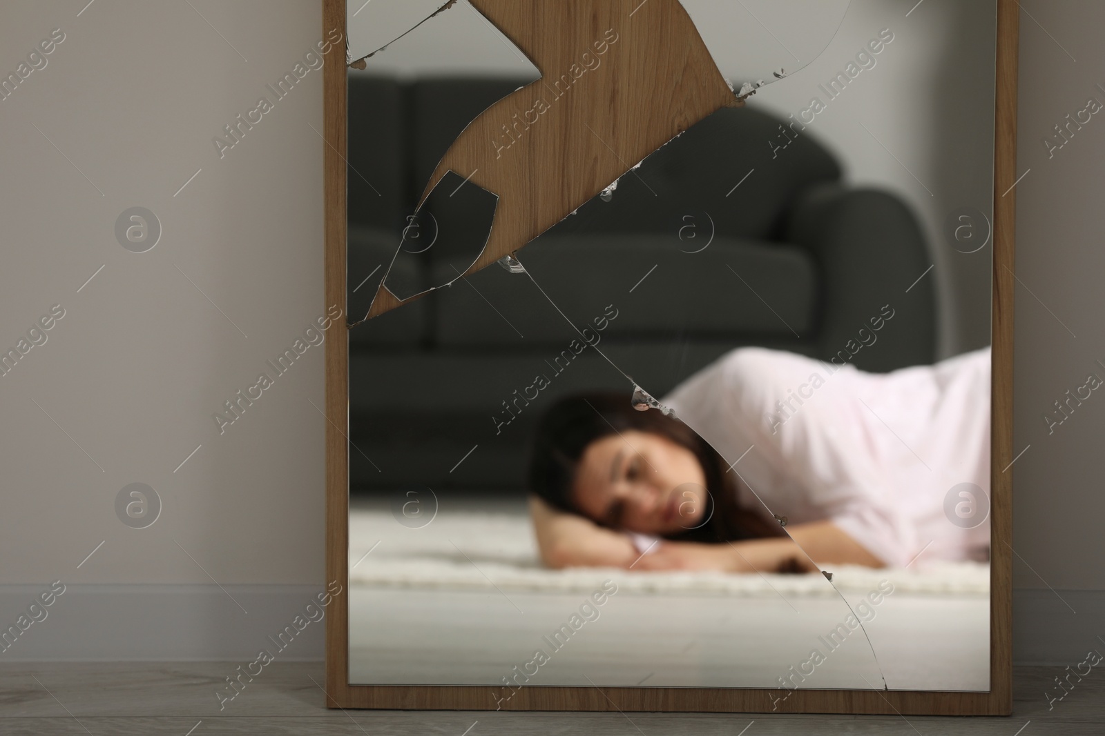 Photo of Mental problems. Blurred reflection of depressed woman in mirror indoors