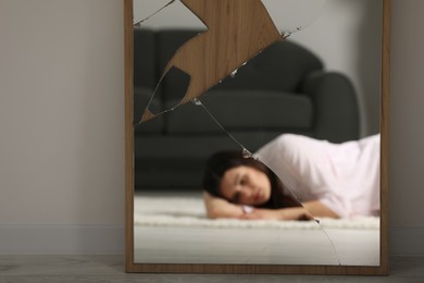 Photo of Mental problems. Blurred reflection of depressed woman in mirror indoors