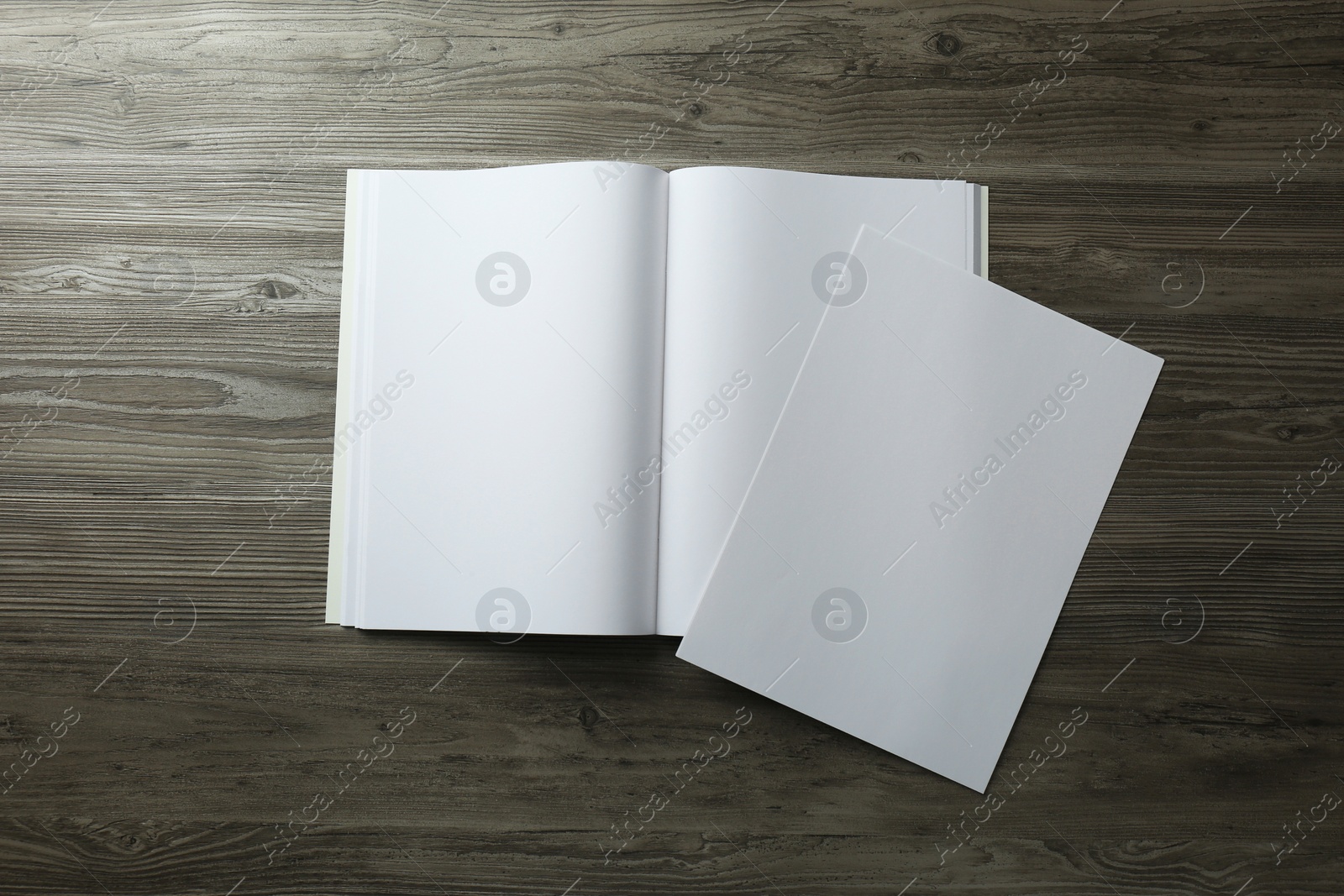 Photo of Sheet of paper and blank brochure on wooden table, flat lay. Mockup for design