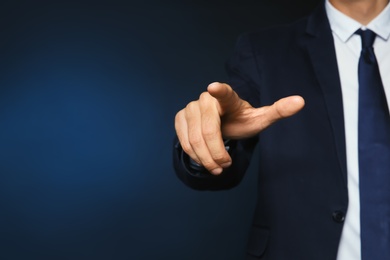 Photo of Businessman pointing on color background, closeup view of hand with space for text