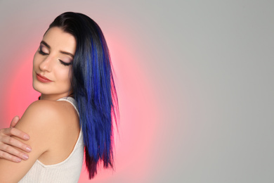 Photo of Young woman with bright dyed hair on color background, space for text