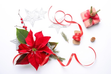 Photo of Flat lay composition with beautiful poinsettia and gift on white background. Christmas traditional flower