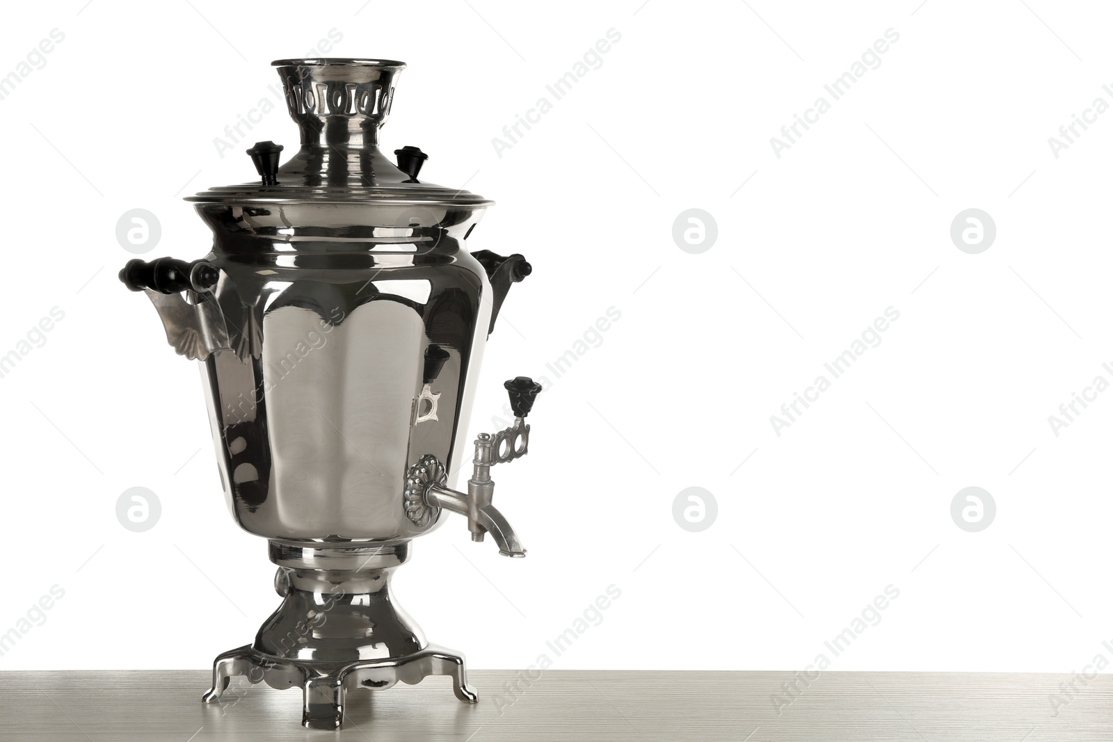 Photo of Traditional Russian samovar on wooden table against white background. Space for text