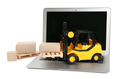 Photo of Laptop, toy forklift, wooden pallets and boxes on white background