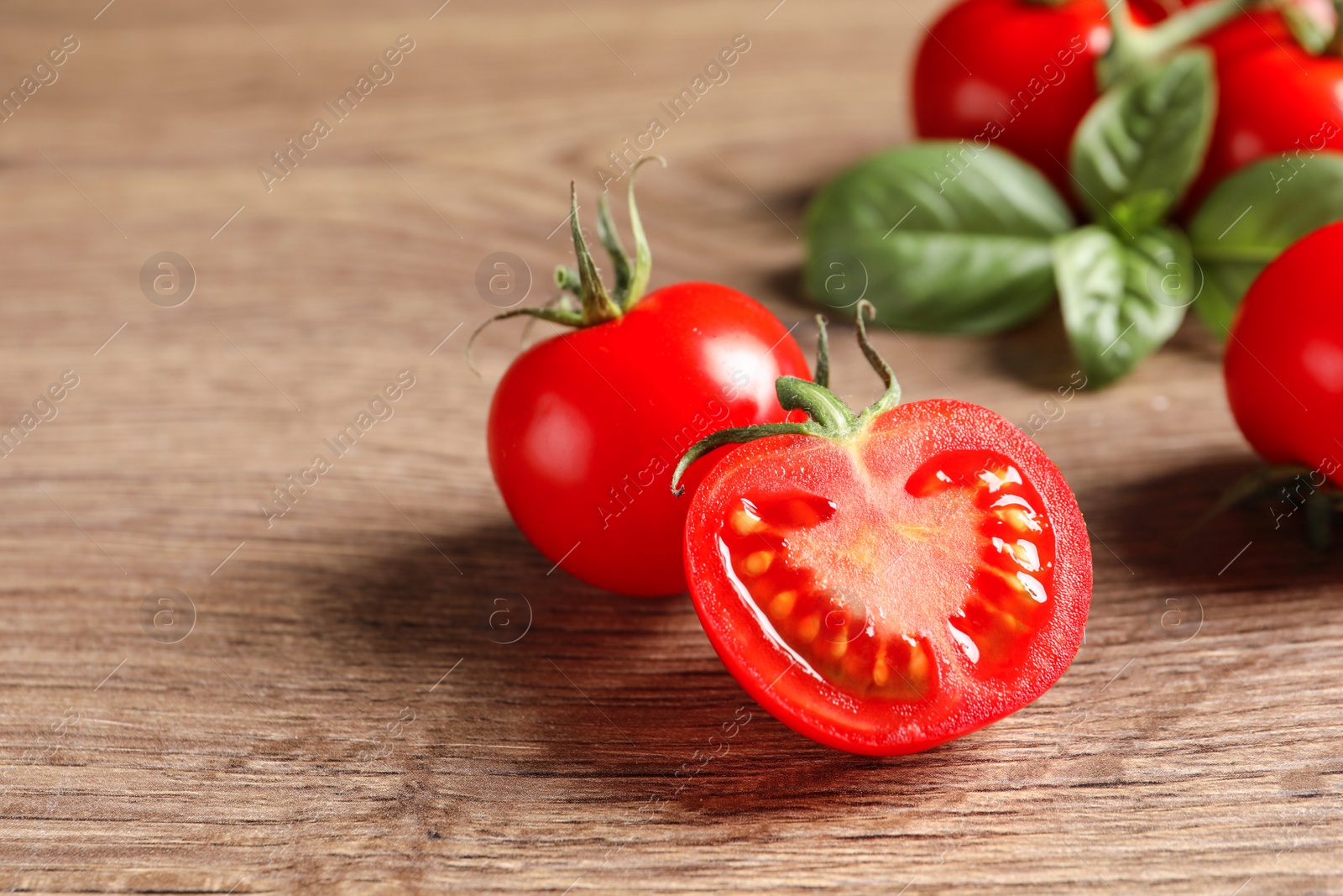 Photo of Fresh cherry tomatoes on wooden background, closeup. Space for text