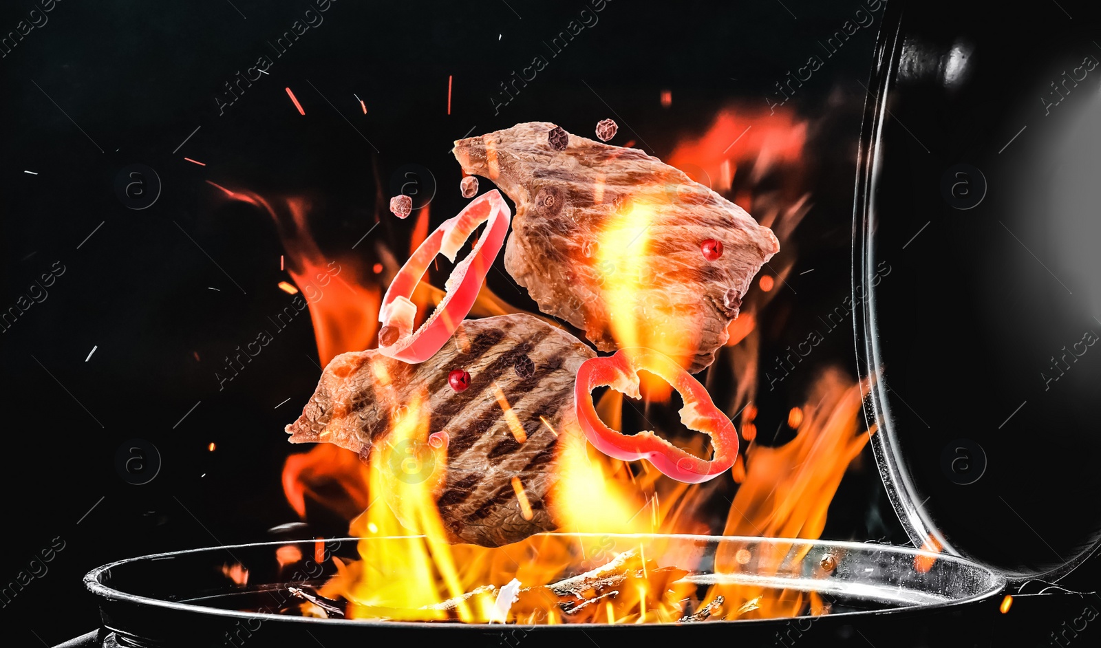 Image of Meat and bell pepper slices falling onto barbecue grill with flame against black background, closeup