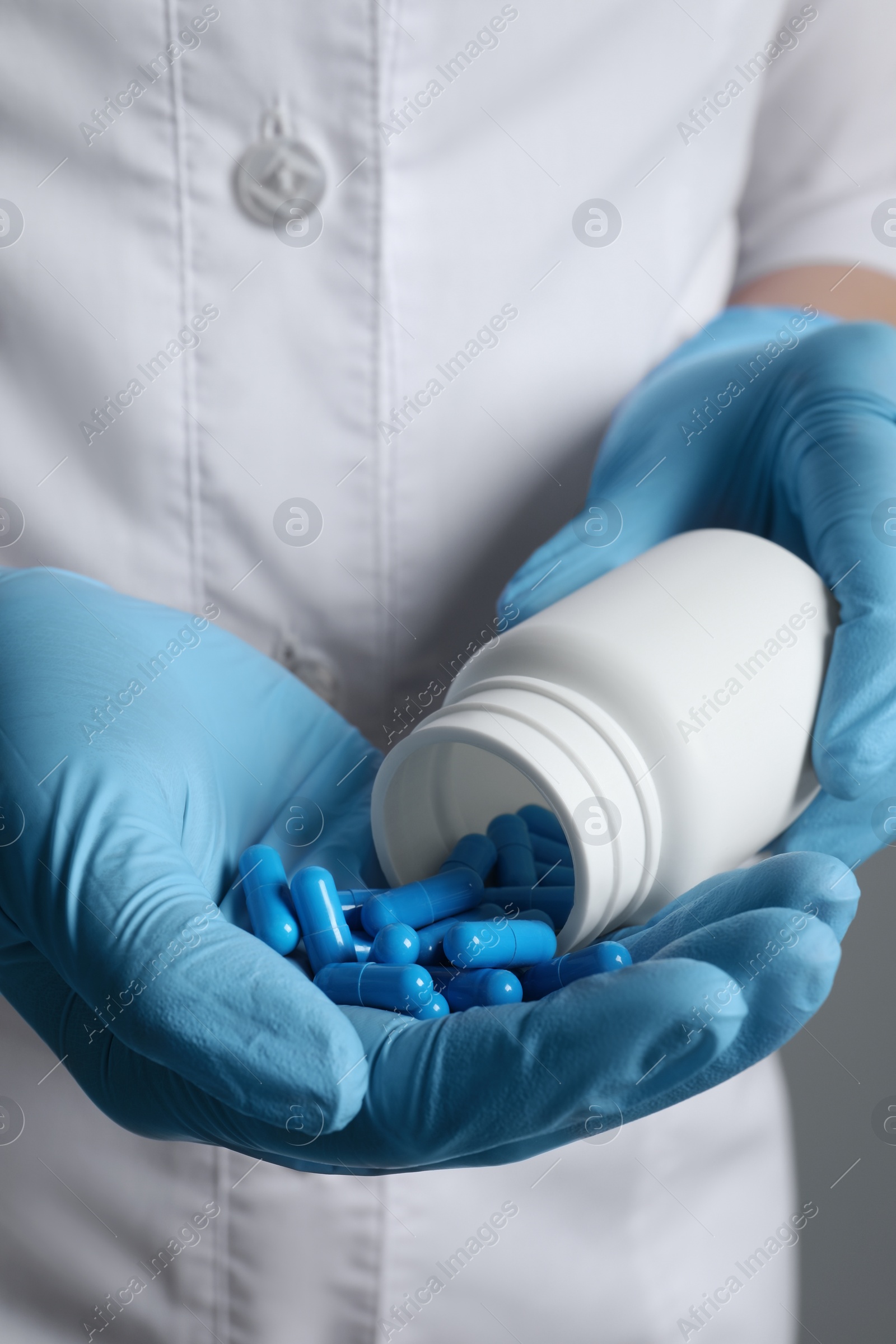 Photo of Doctor pouring pills from bottle onto hand, closeup view