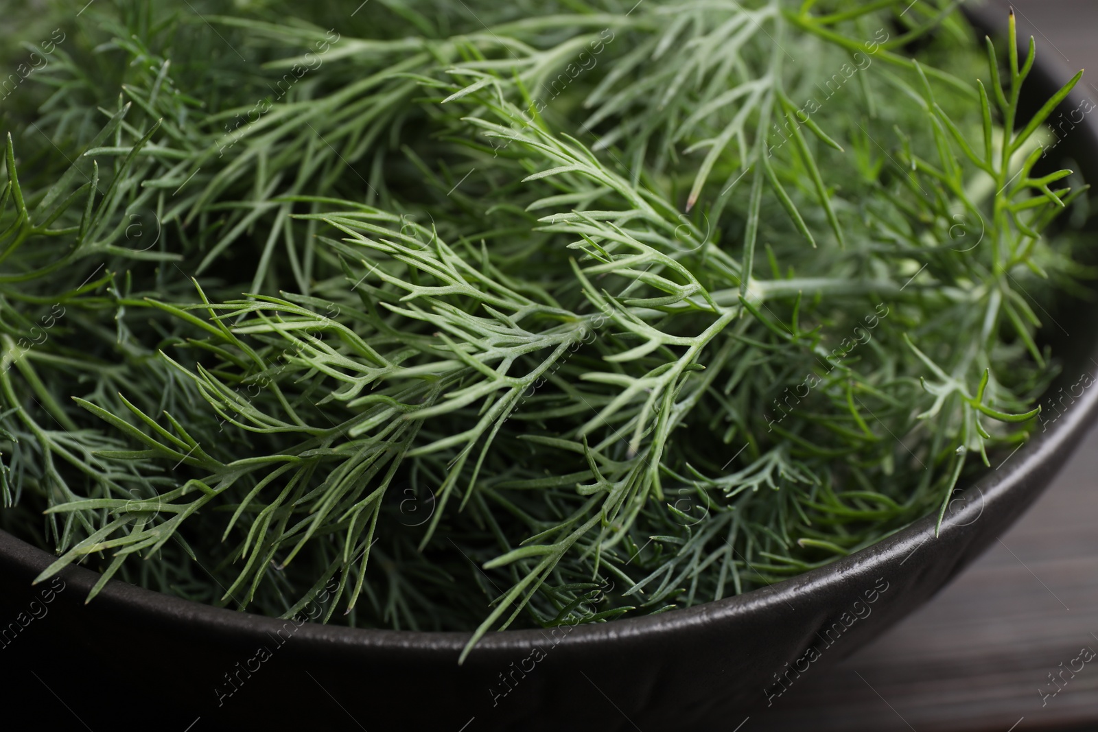 Photo of Bowl of fresh dill on table, closeup