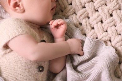 Photo of Cute newborn baby lying on beige crocheted plaid, top view
