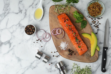 Delicious salmon with spinach and avocado served on white marble table, flat lay