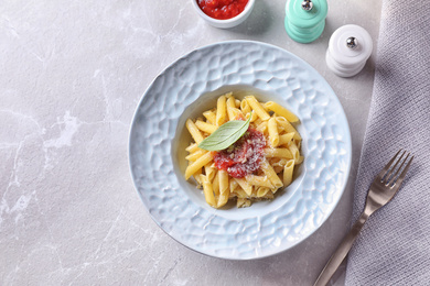 Photo of Delicious pasta with tomato sauce served on light table, flat lay