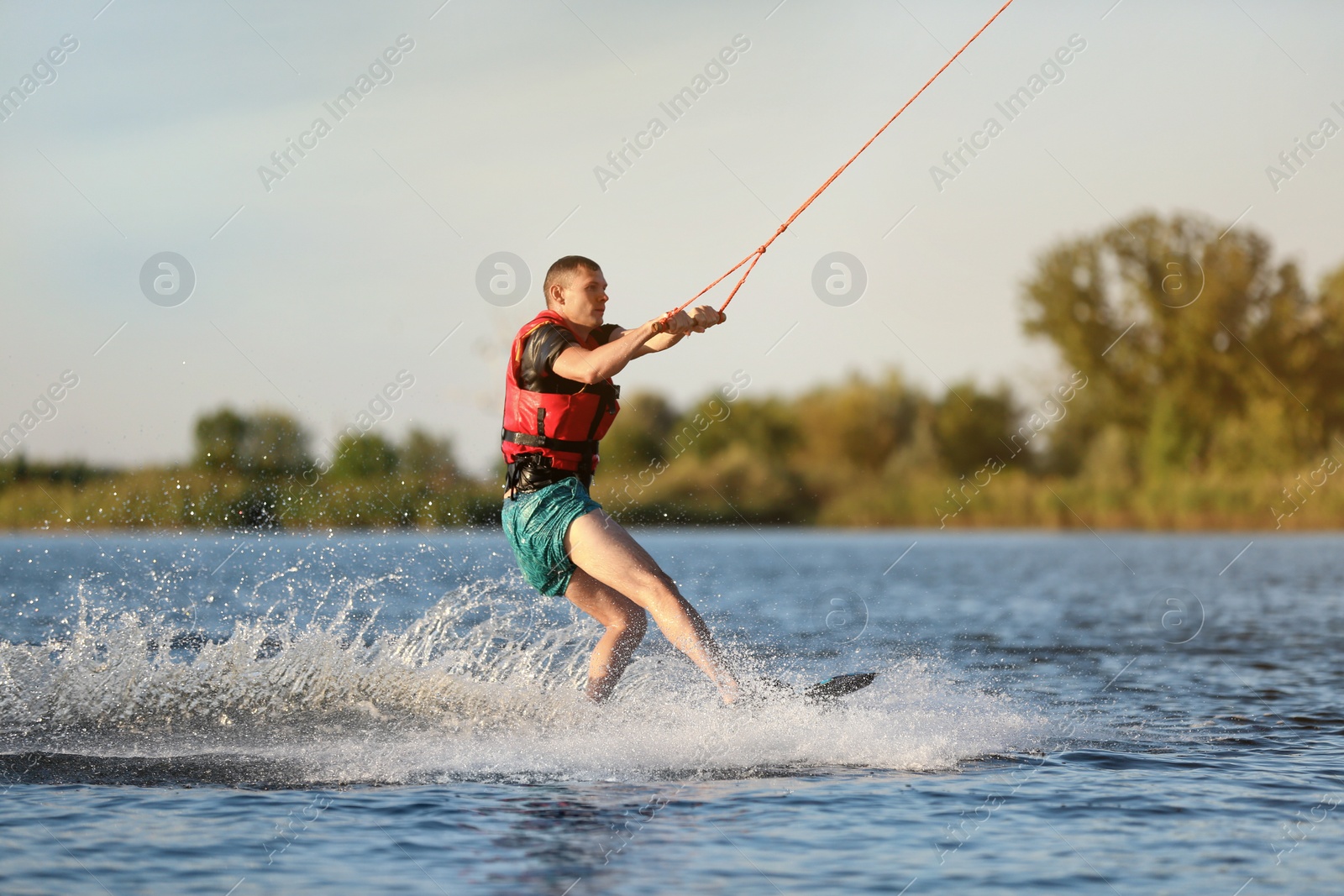 Photo of Man wakeboarding on river. Extreme water sport