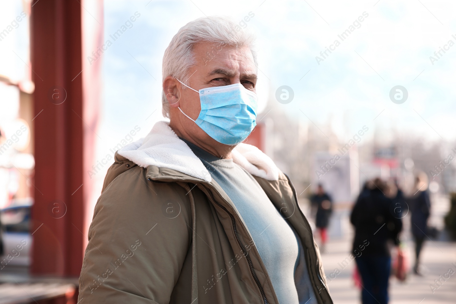 Photo of Senior man with medical mask on city street. Virus protection