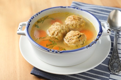 Bowl of Jewish matzoh balls soup on wooden background table