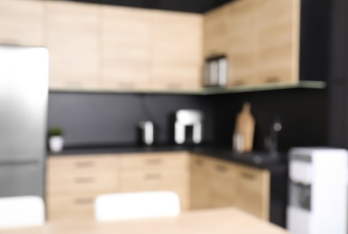 Photo of Blurred view of cozy modern kitchen interior with new furniture and appliances