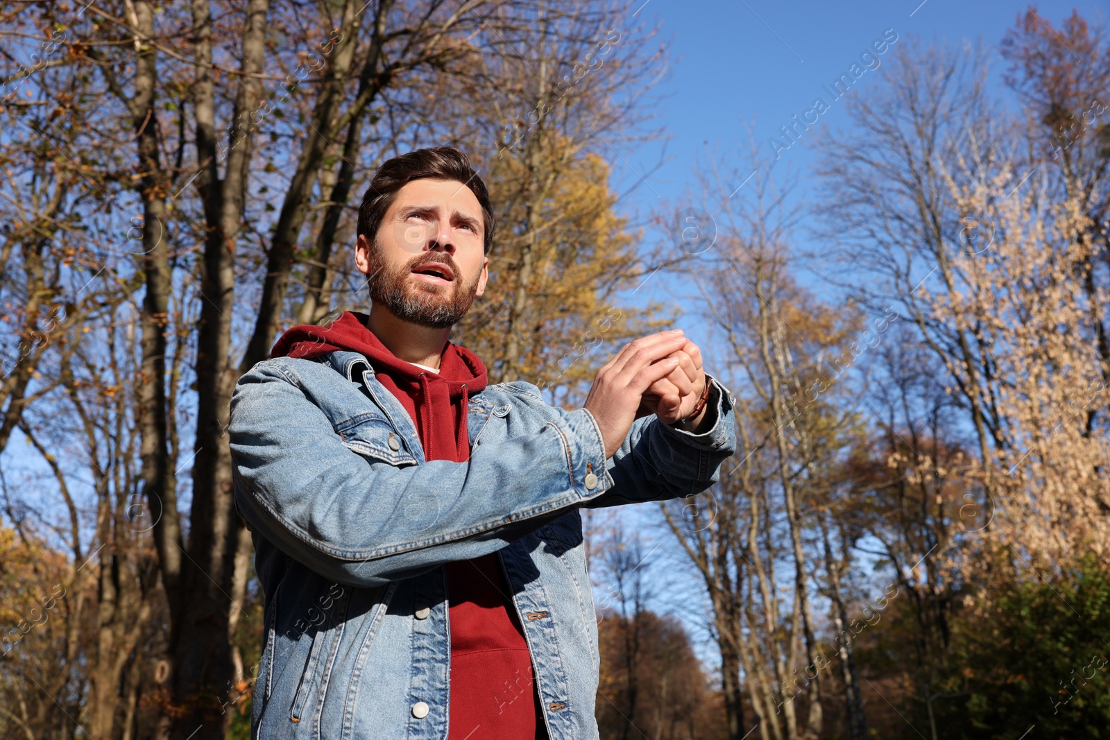 Photo of Man checking time on watch outdoors. Being late concept