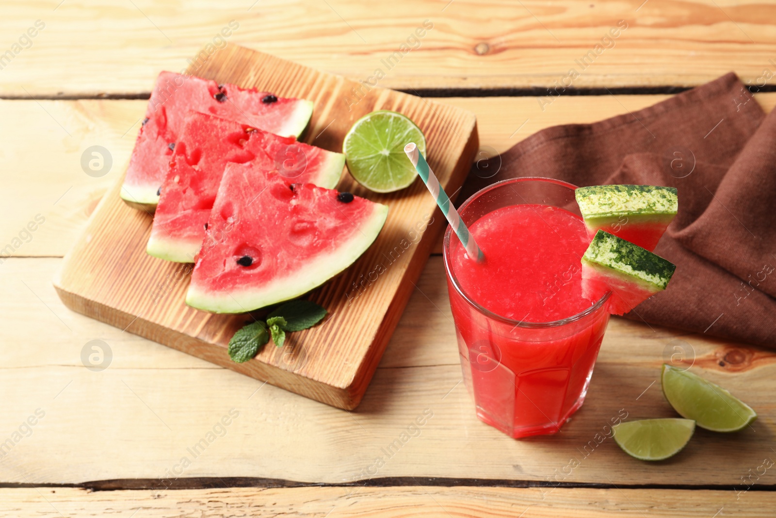 Photo of Summer watermelon drink in glass and sliced fruits on table