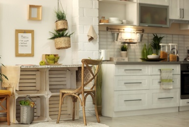 Photo of Modern kitchen interior with wooden crates as eco furniture