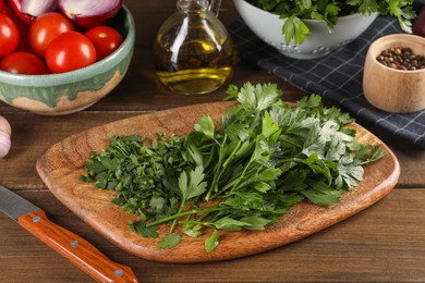 Photo of Fresh green parsley and different products on wooden table
