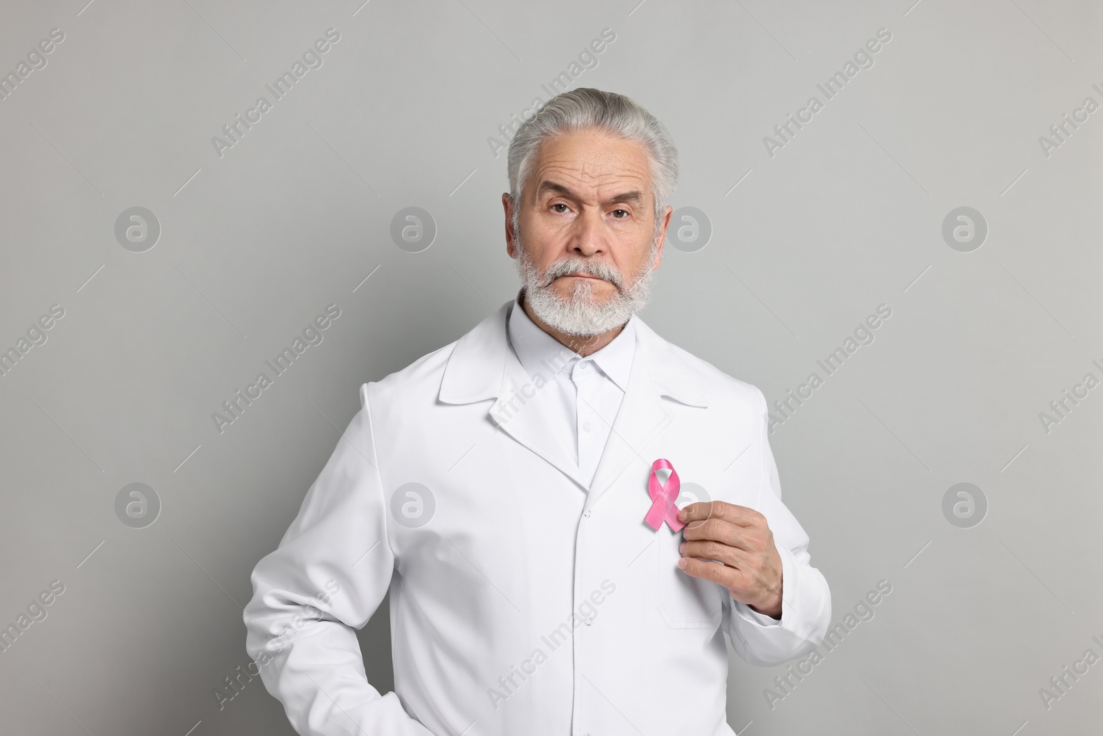 Photo of Mammologist with pink ribbon on gray background. Breast cancer awareness