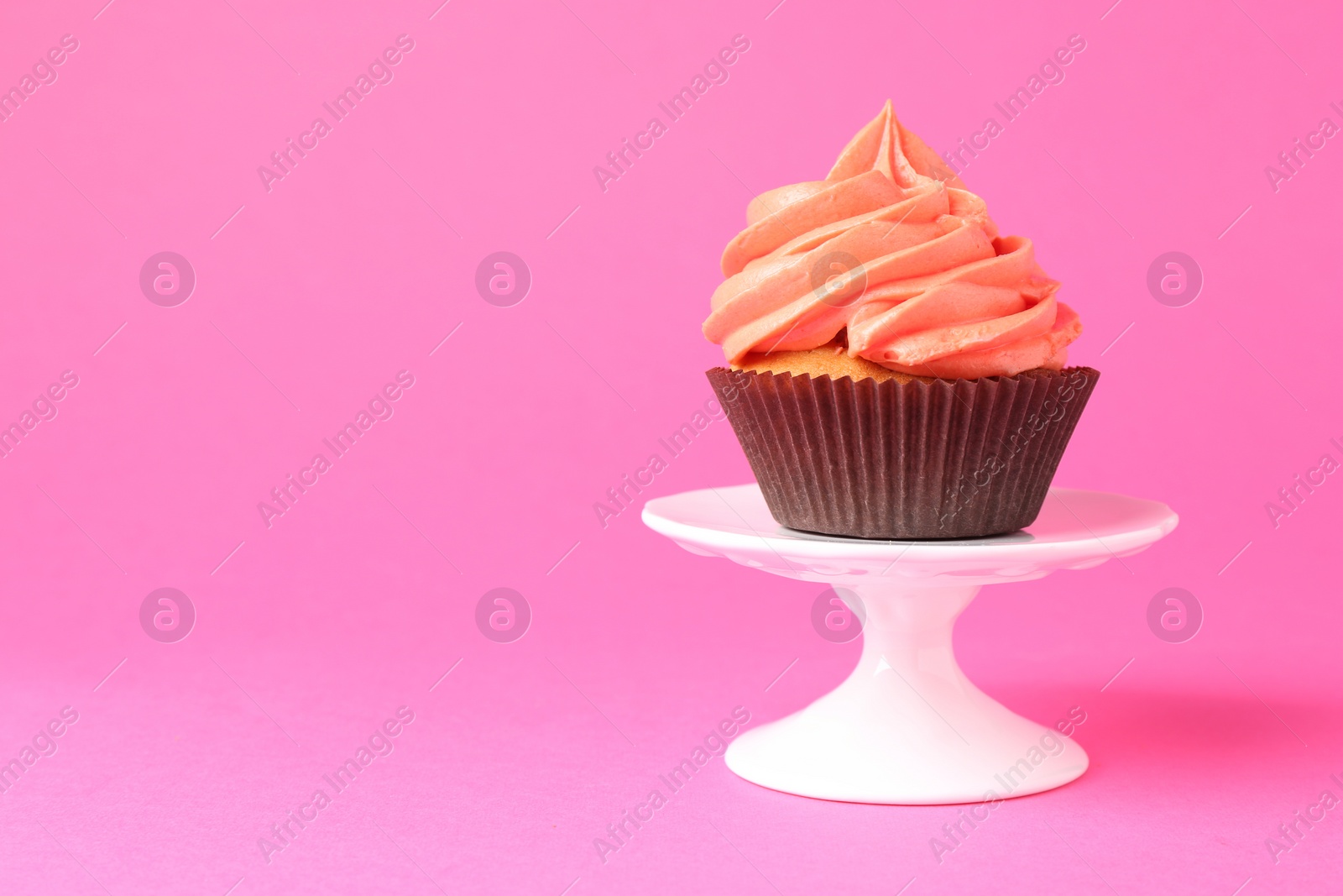 Photo of Delicious cupcake with bright cream on pink background. Space for text