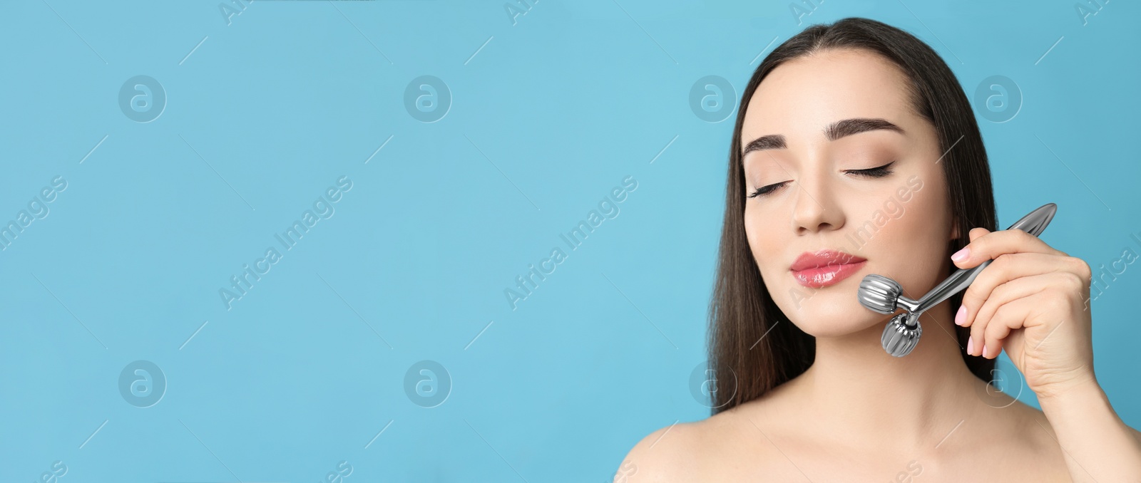 Image of Woman using metal face roller on light grey  background, space for text. Banner design