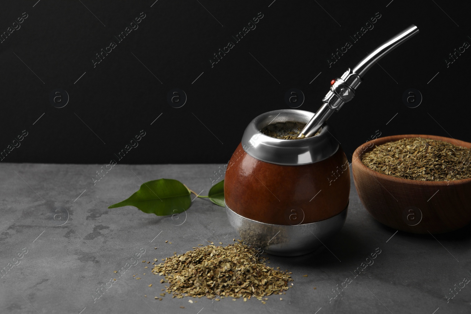 Photo of Calabash with mate tea and bombilla on light grey table. Space for text