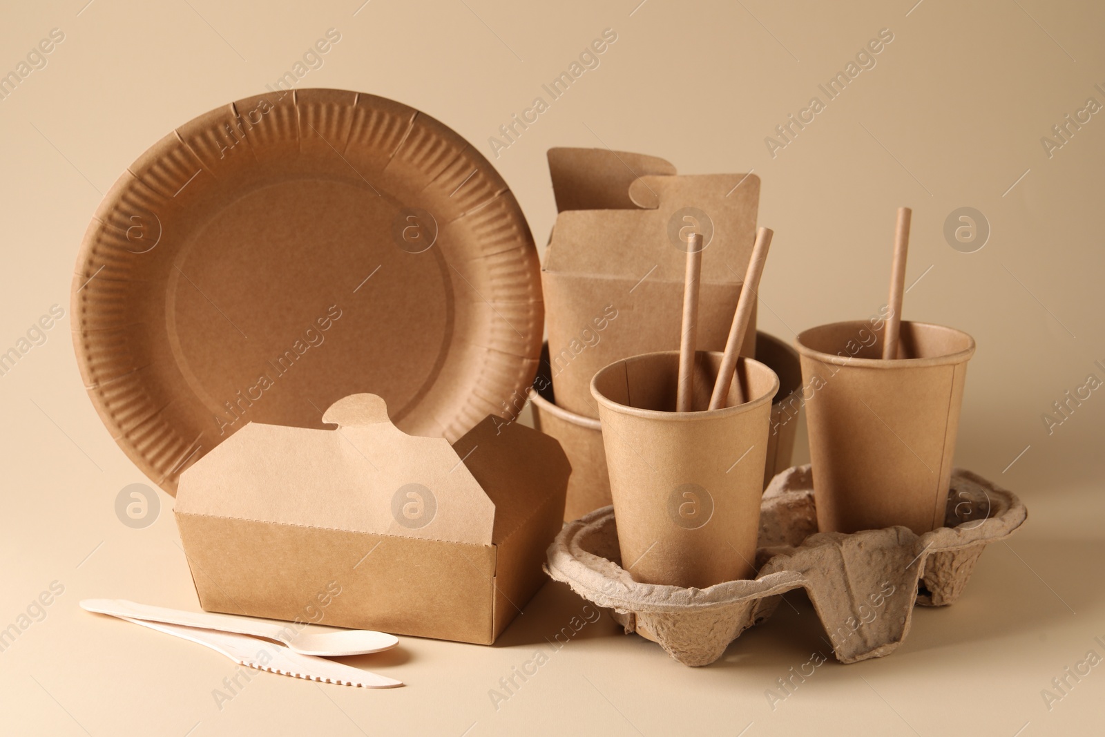 Photo of Eco friendly food packaging. Paper containers and tableware on beige background