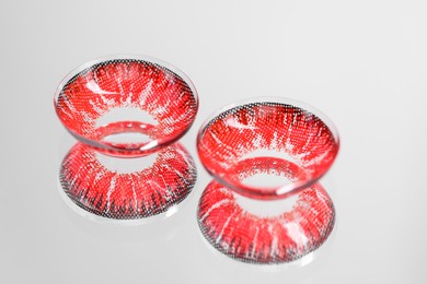 Photo of Two red contact lenses on mirror surface