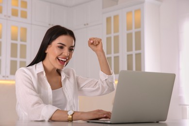 Emotional woman participating in online auction using laptop at home