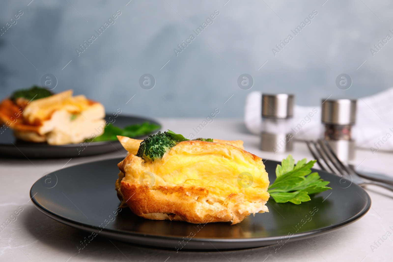 Photo of Tasty broccoli casserole served on grey table