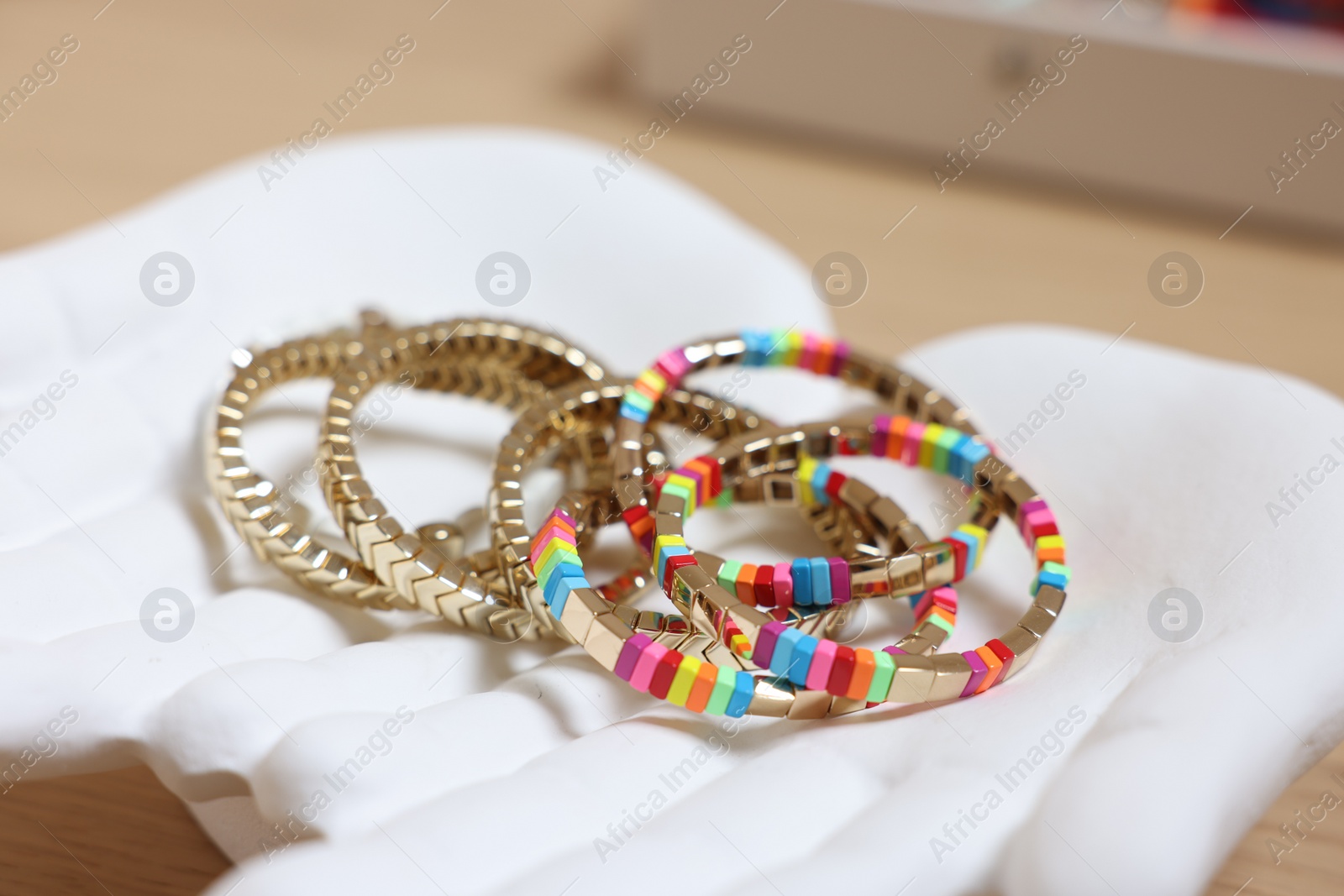 Photo of Ceramic hand stand with many different bracelets on table, closeup